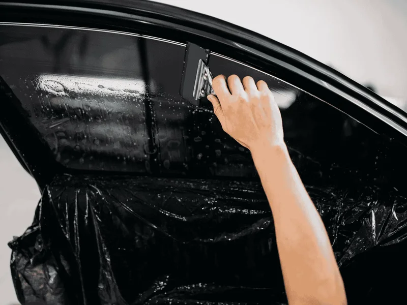 Technician applying dyed window tint film